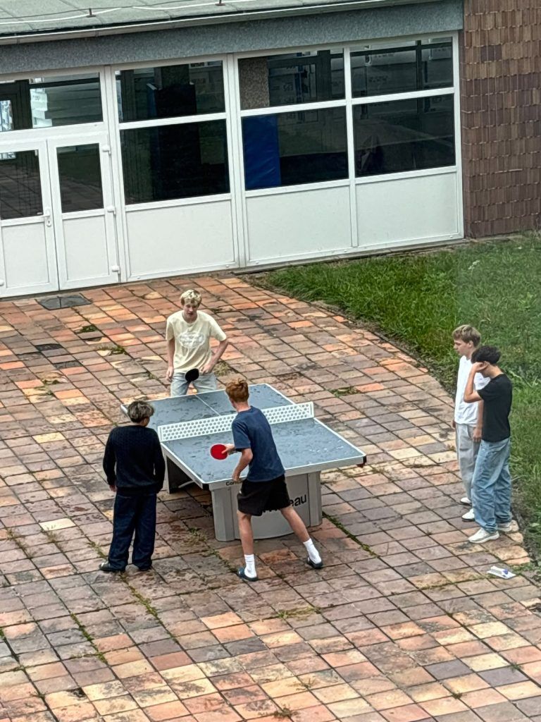 Žáci hrají ping pong na novém stole ve vnitrobloku školy